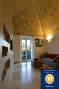 ein Wohnzimmer mit einem Sofa und einem großen Fenster in der Unterkunft L'Affaccio Dell'Abate in Matera