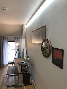 Zimmer mit einer Uhr an der Wand und einem Tisch in der Unterkunft Gut Hohenholz in Bedburg