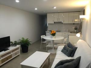 プエルト・デル・カルメンにあるApartamento Playa Encantadorのソファとテーブルとキッチンのあるリビングルーム