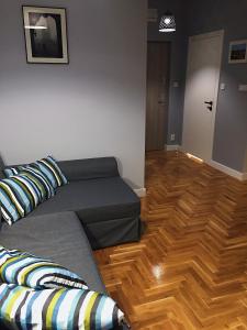 sala de estar con sofá y suelo de madera en Grey Apartments Kościuszko en Cracovia