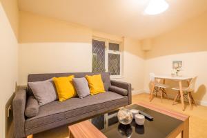 uma sala de estar com um sofá e uma mesa em Skyline Serviced Apartments - Colestrete em Stevenage