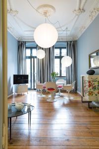 a living room with two chandeliers and a table at Brilliant Apartments in Berlin
