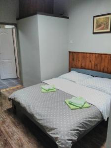 a bedroom with a bed with green towels on it at Apartman Merkur in Sombor