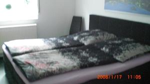 a bed with black and white sheets on it at Apartment Gerda in Dieburg