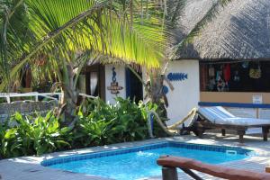 a swimming pool in front of a house with a resort at Zona Braza Beach Lodge in Chizavane