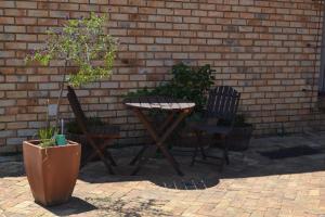 a table and two chairs next to a brick wall at The Lazy Grape Guest Lodge & Spa in Benoni