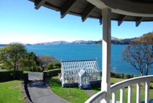 - une vue sur l'eau depuis la terrasse couverte d'une maison dans l'établissement St Leonards Lodge, à Dunedin