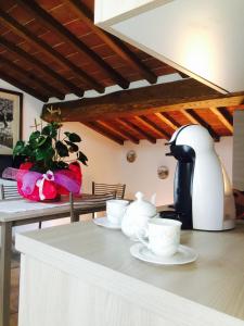 una mesa con dos tazas y una cafetera en ella en Mansarda degli Ulivi, en Rigomagno