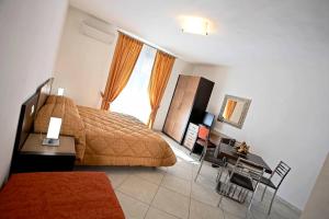 um quarto com uma cama, uma secretária e uma janela em Residence I Gabbiani em Portovenere
