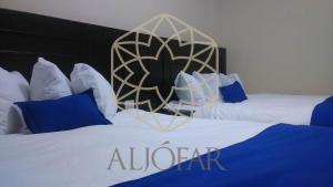 2 camas en una habitación de hotel con un cartel de elevación en Hotel Aljófar, en Montemorelos