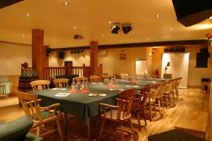 een lange tafel in een kamer met stoelen en tafels bij Guy's Thatched Hamlet in Barton