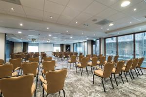 a room with rows of chairs in a room with windows at Bilderberg Château Holtmühle in Venlo +34 photos
