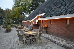 eine Terrasse mit Tischen und Stühlen neben einem Backsteingebäude in der Unterkunft Herberg Sellingen in Sellingen