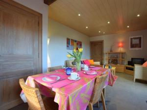een eetkamer met een tafel met een roze tafelkleed bij Peaceful Cottage in Ardennes with Private Terrace in Bastenaken