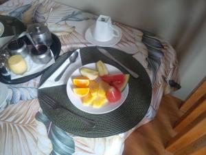 a plate of fruit on a table on a bed at La Kaz Safran in La Digue