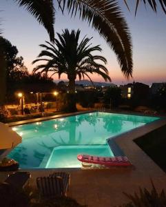 una gran piscina con una palmera en el fondo en Argo Apartments, en Kato Daratso
