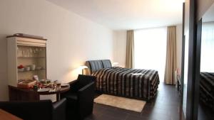 a room with a bed and a table and a chair at Campus Boardinghouse in Aachen