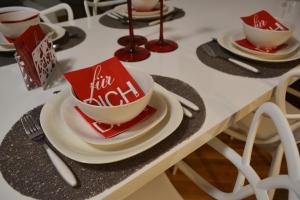 a table with plates and cups and utensils at Apartment Fine Living 122 in Vršac