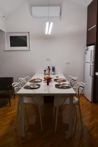una cucina con tavolo e sedie bianchi in una stanza di Apartment Fine Living 122 a Vršac
