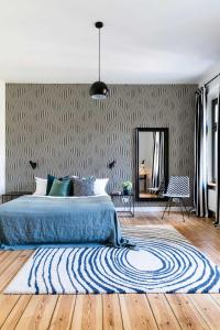 a bedroom with a blue bed and a mirror at Brilliant Apartments in Berlin