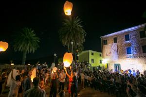 a crowd of people holding lanterns in front of a building at Apartments Stanisic in Herceg-Novi
