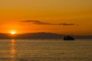 a boat in the ocean at sunset at Hotel Avra in Perea