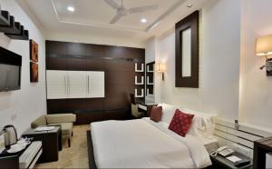 1 dormitorio con 1 cama blanca grande y escritorio en Hotel D'PRESIDENTE, en Nueva Delhi