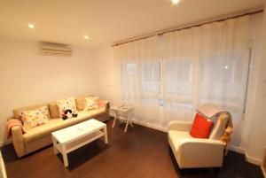 uma sala de estar com um sofá e uma cadeira em Apartamento Puerto-Terol em Alicante