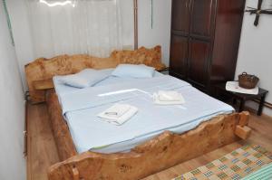Una cama con dos toallas blancas encima. en Inn Cakmara en Raška