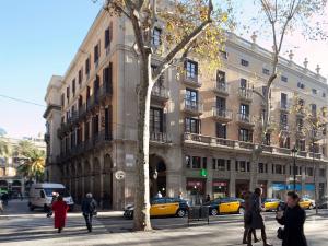 un groupe de personnes marchant dans une rue devant un bâtiment dans l'établissement HOTEL FORNOS - Barcelona, à Barcelone