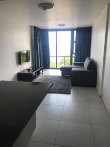 a large living room with a couch and a tv at Toti Oasis Holiday Apartments in Amanzimtoti