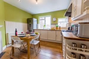 a kitchen with green walls and a wooden table and chairs at Blake Street in York