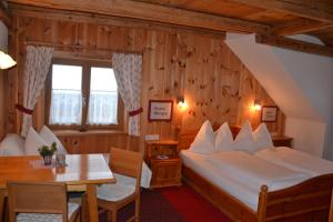 a bedroom with a bed and a table and a desk at Holdhof in Schladming