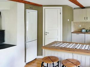 eine Küche mit zwei Hockern und einem weißen Kühlschrank in der Unterkunft One-Bedroom Holiday home in Valdemarsvik in Gryt
