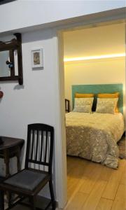 a bedroom with a bed and a chair and a table at Casinhas da Ajuda nº25 in Lisbon