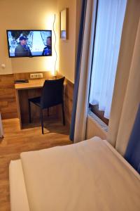 a hotel room with a bed and a desk with a television at Arthotel Munich in Munich
