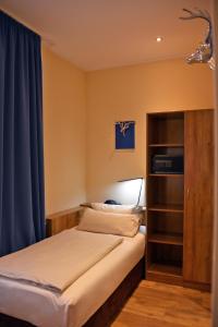 a bedroom with a bed with a blue curtain at Arthotel Munich in Munich