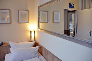 a room with a mirror and a bed with pillows at Arthotel Munich in Munich