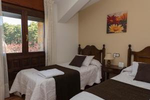 1 dormitorio con 2 camas y ventana en Hotel Rural Santa Inés, en Vinuesa