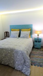 リスボンにあるCasinhas da Ajuda nº25のベッドルーム1室(大型ベッド1台、青いヘッドボード付)