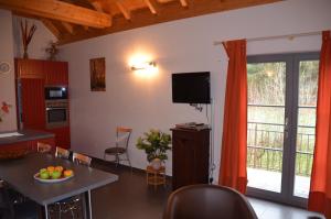 eine Küche und ein Wohnzimmer mit einem Tisch und einem TV in der Unterkunft Bleesmillen in Diekirch