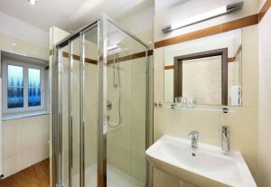 a bathroom with a glass shower and a sink at CK Pension in Český Krumlov