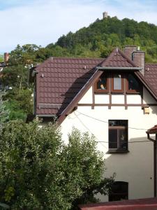 une maison blanche avec un toit marron et une fenêtre dans l'établissement Ferienwohnung Haus "Anna", à Bad Blankenburg