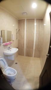 La salle de bains est pourvue de toilettes et d'un lavabo. dans l'établissement Long Yuan Hotel, à Budai