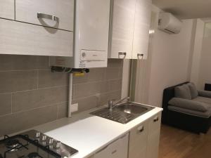 a small kitchen with a sink and a couch at Fewo Südtirol - Apartments in Bolzano