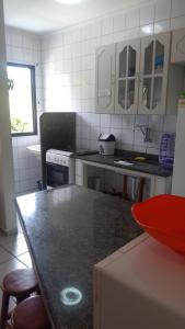 a kitchen with a black counter top in a room at Apartamento em Ubatuba próximo a praia! in Ubatuba