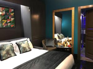 una camera d'albergo con letto e specchio di Maison Torre Argentina a Roma