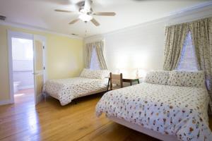 um quarto com 2 camas e uma ventoinha de tecto em Swamp Rabbit Inn Travelers Rest em Travelers Rest