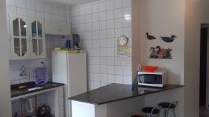 uma cozinha com um frigorífico e um micro-ondas no balcão em Apartamento em Ubatuba próximo a praia! em Ubatuba