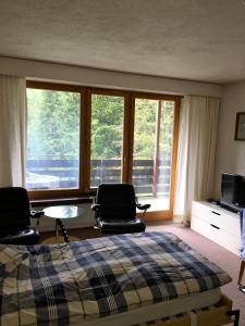 アローザにあるCasa Marlencaのベッドルーム1室(椅子2脚、ベッド1台、窓付)